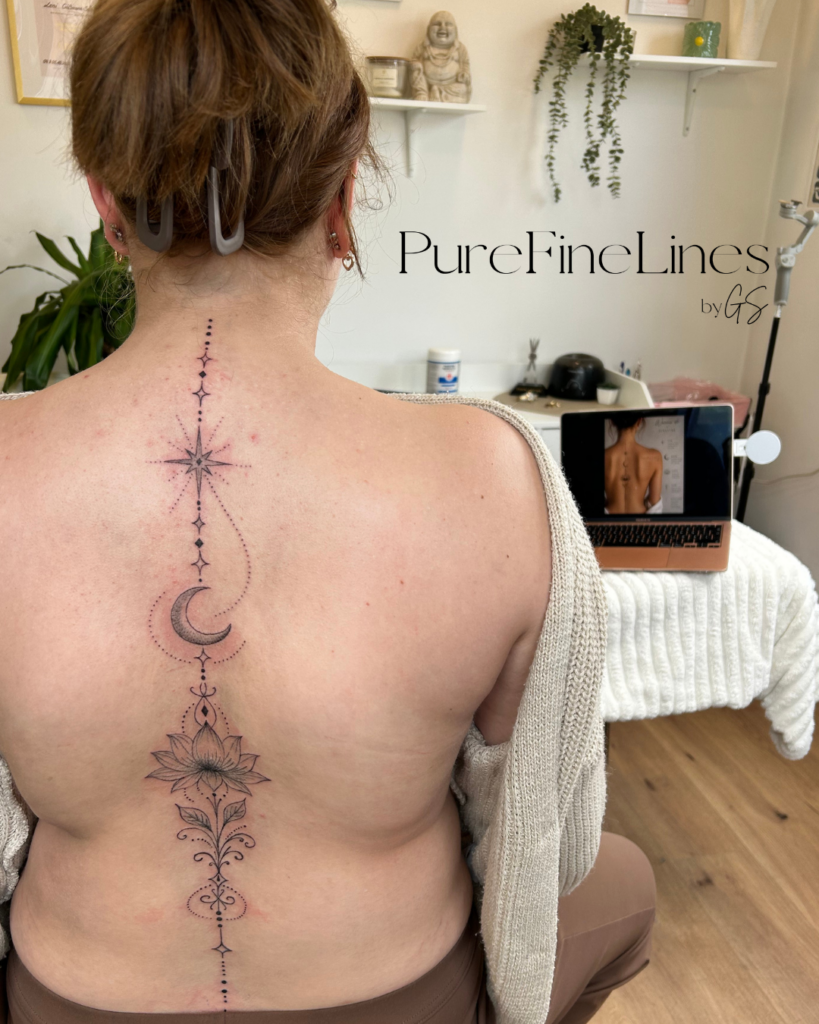Filigranes Fineline Tattoo entlang der Wirbelsäule mit Stern, Mond und Blüten-Ornament am Rücken, PureFineLines by GS in Saal a.d. Saale